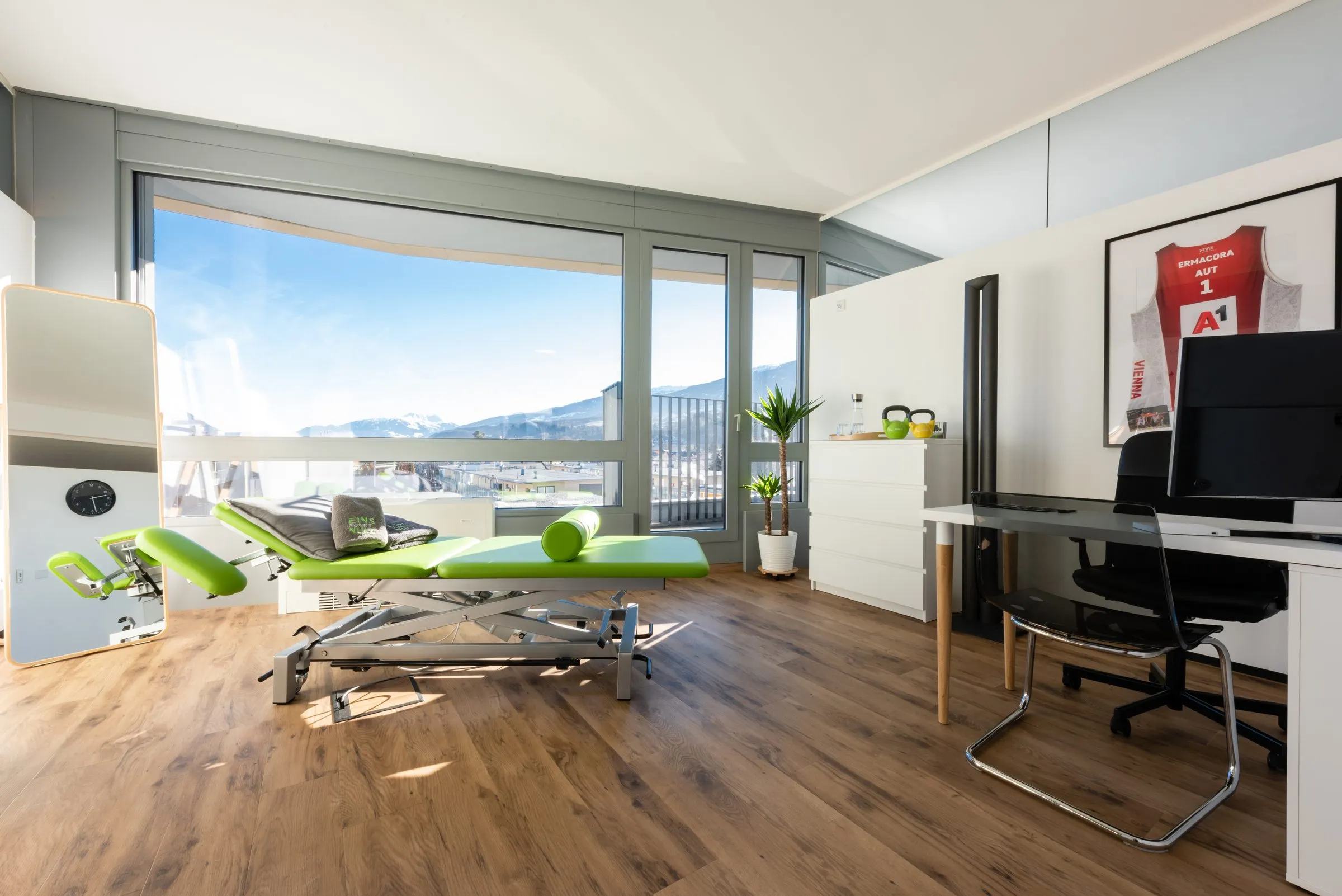 Behandlungsraum der Praxis Physio 1.0 mit Liege und Blick auf die verschneite Nordkette