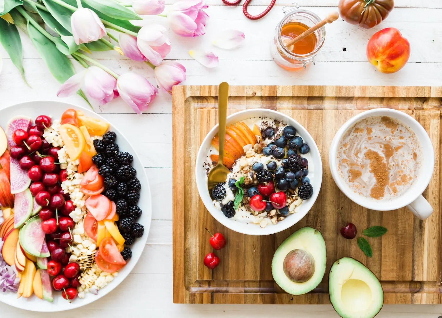 Frühstückstisch mit Obst, Bowl, Avocado und Kaffee