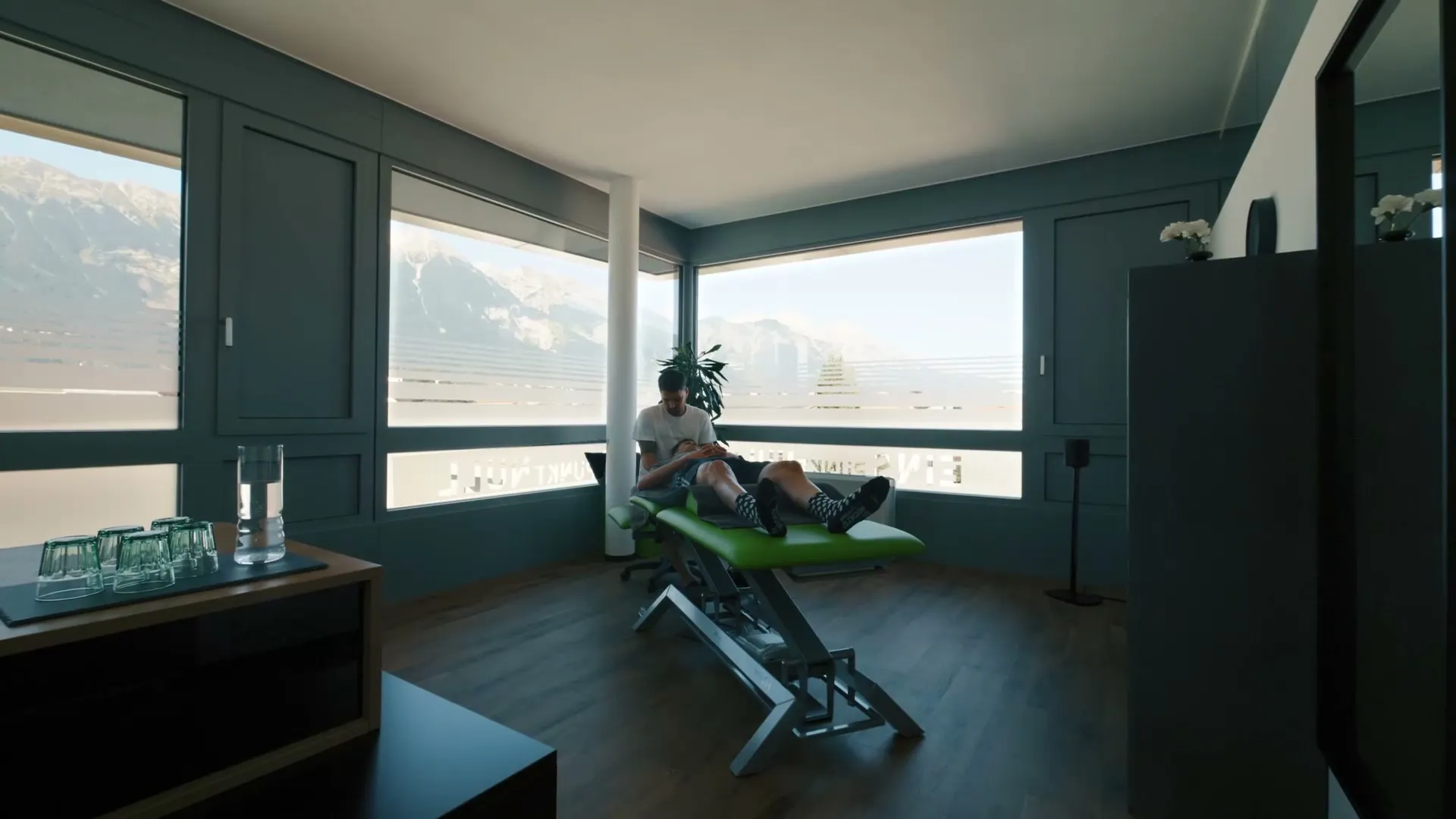 Behandlungsraum von Physio 1.0 in Innsbruck mit Fensterfront und Blick auf die Berge