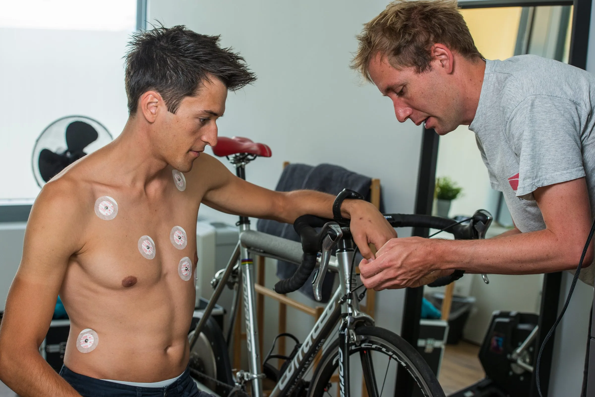 Sportler mit EKG-Elektroden wird für die Leistungsdiagnostik am Rad vorbereitet